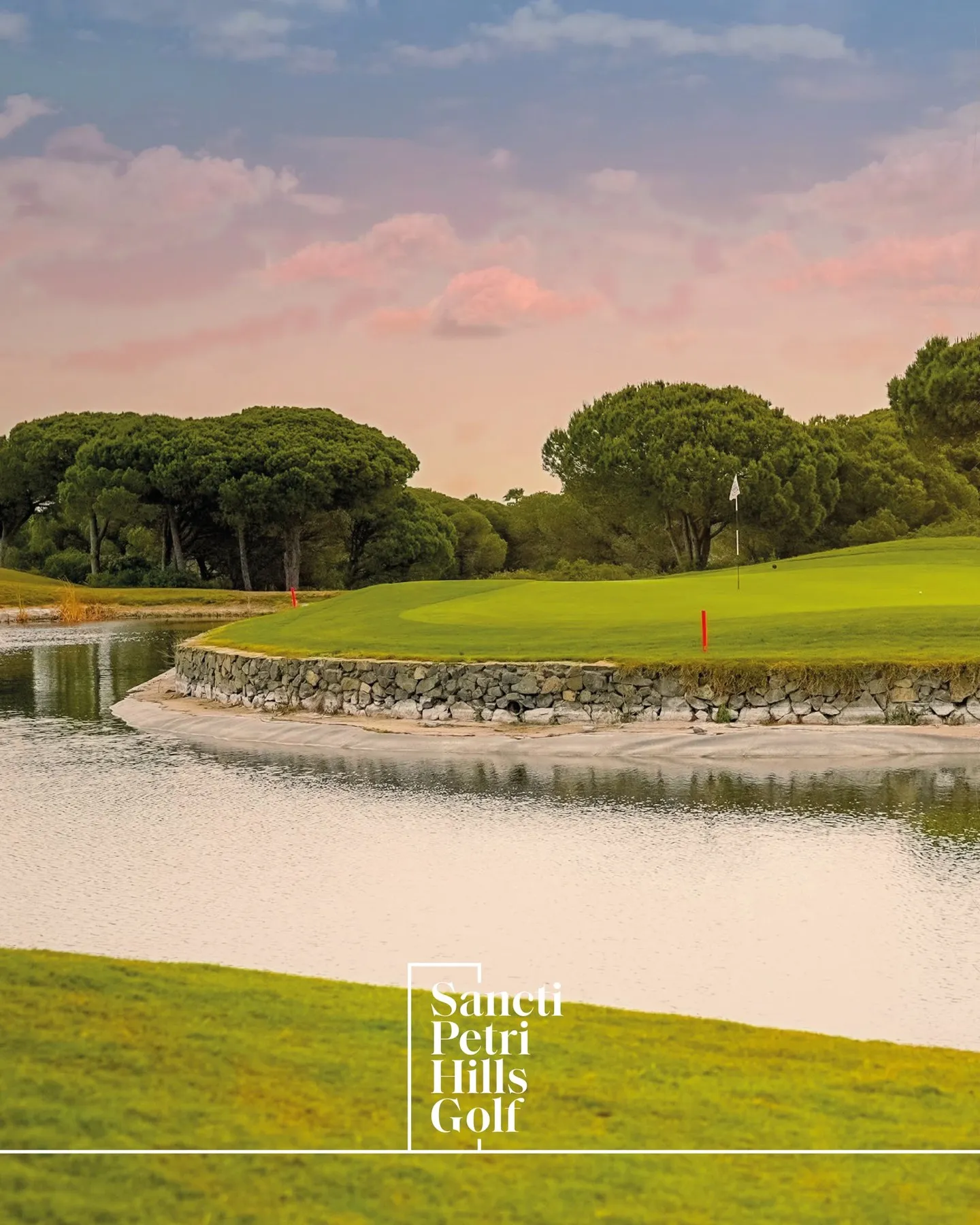 Green junto al lago entre pinos bajo un cielo rosado, golf en otoño en Sancti Petri Hills Golf, Chiclana