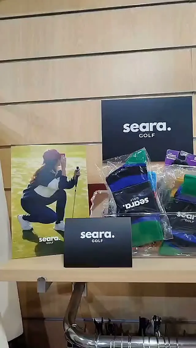 Calcetines a rayas y carteles de Seara Golf en una balda de la pro shop de Sancti Petri Hills
